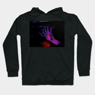 Digital collage, special processing. Hand laying on some wet surface. Psychedelic. Colorful. Blue, violet and red. Hoodie